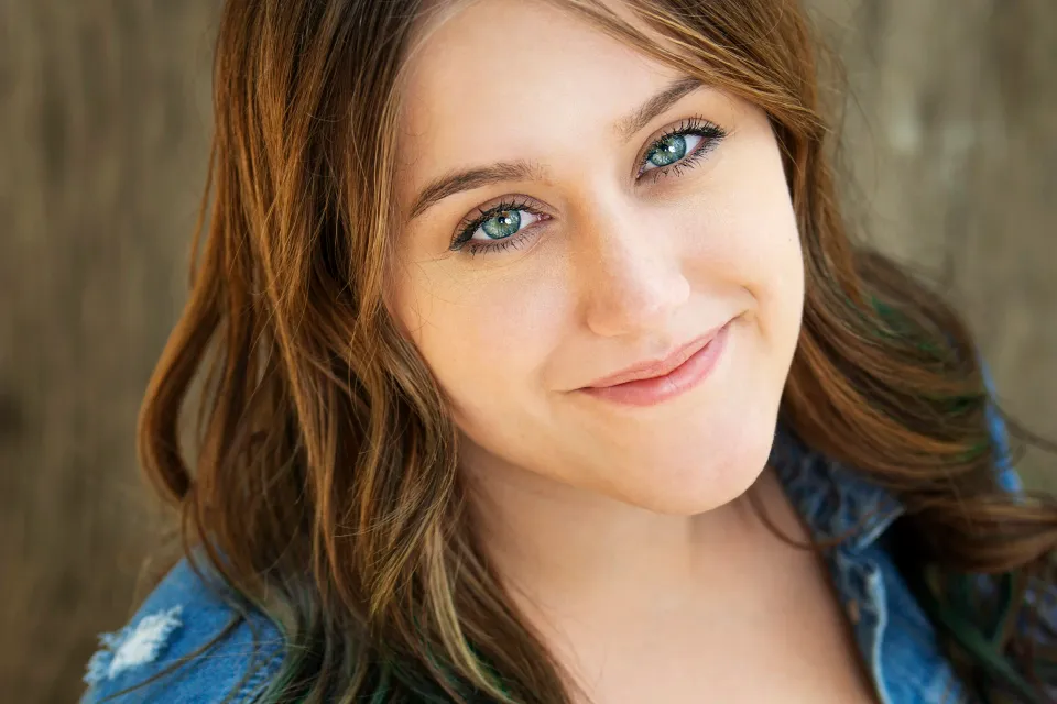 Retrato de Alexus Miller sonriendo con una chaqueta de mezclilla