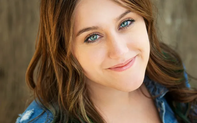 Retrato de Alexus Miller sonriendo con una chaqueta de mezclilla